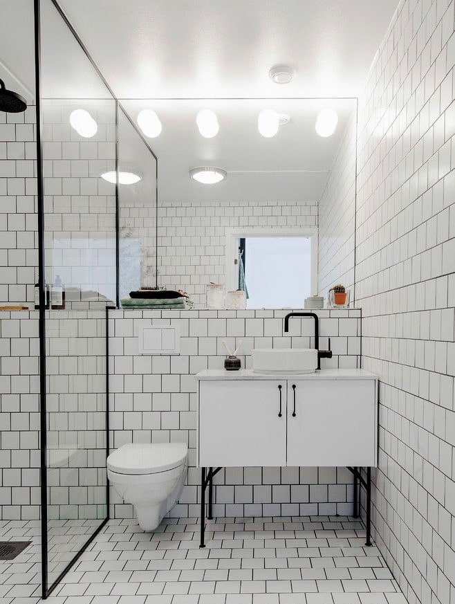 witte tegels met voegsel in het interieur van de badkamer