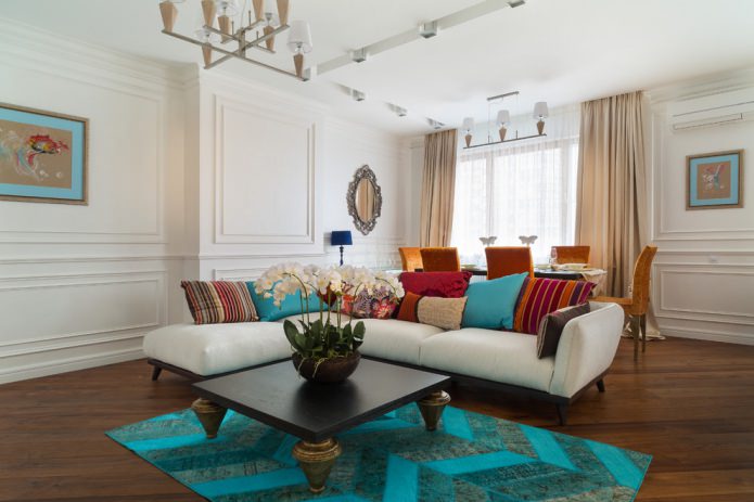 woonkamer met turquoise tapijt en kussens