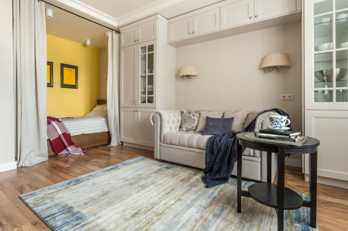 Bed achter gordijnen en een bank in een boog