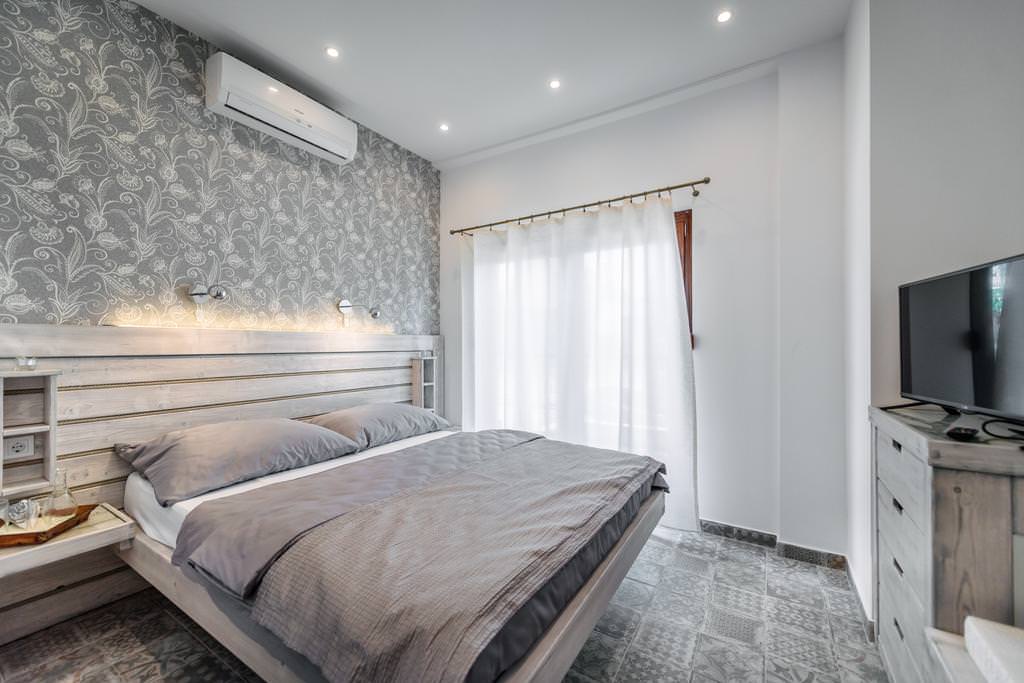witte gordijnen in het ontwerp van de slaapkamer met grijs behang