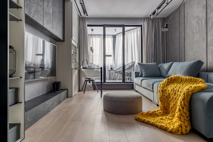 grijs woonkamerinterieur met een felgekleurde deken