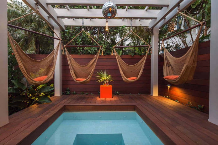 4 hangmatten rond het zwembad met een pergola