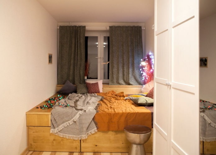 bed op een podium in een kleine kamer