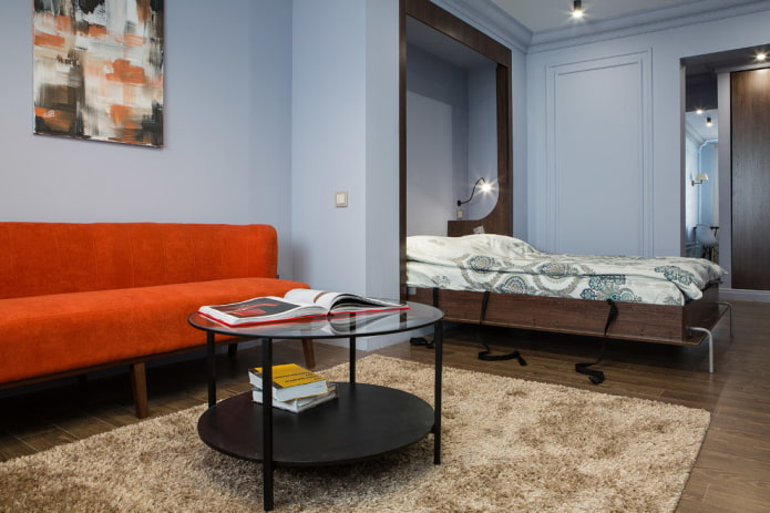 Woonkamer met een bank en een transformeerbaar bed