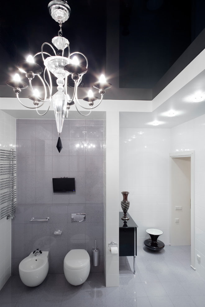 spanplafond met een kroonluchter in de badkamer