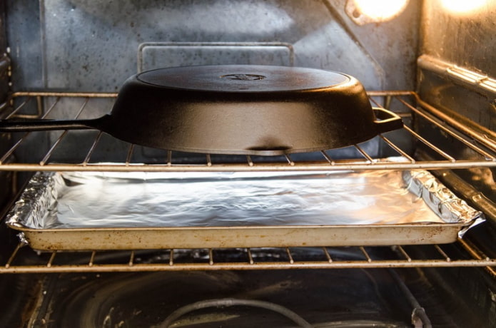 een gietijzeren koekenpan in de oven inbranden