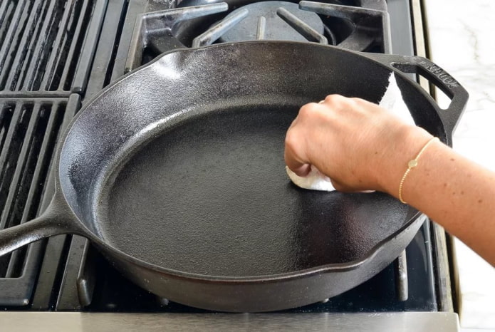 een schone gietijzeren koekenpan smeren met olie
