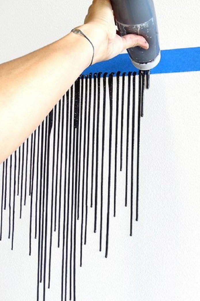 een streep zwarte verfdruppels op de muur