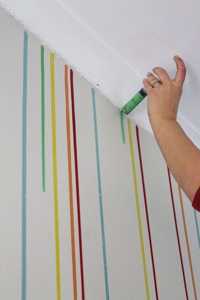 verfdruppels op de muur aanbrengen met een spuit