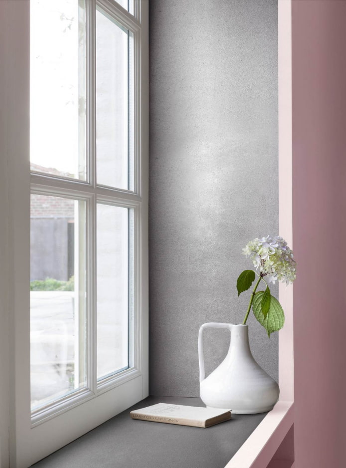 grijze decoratieve pleister op de hellingen van de roze kamer