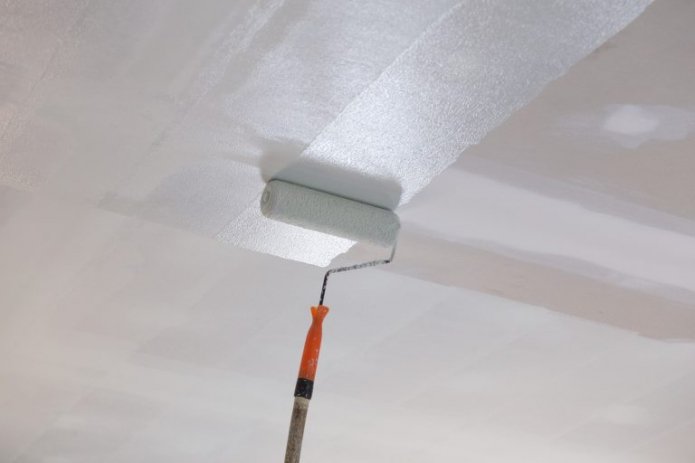 Het plafond schilderen met een roller