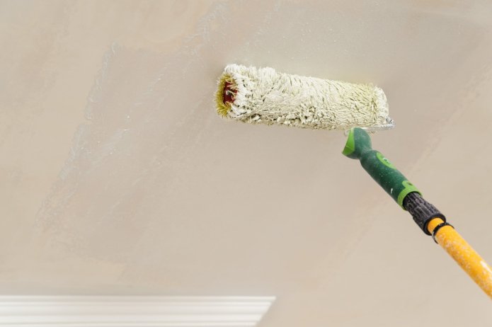 Het plafond schilderen met een roller
