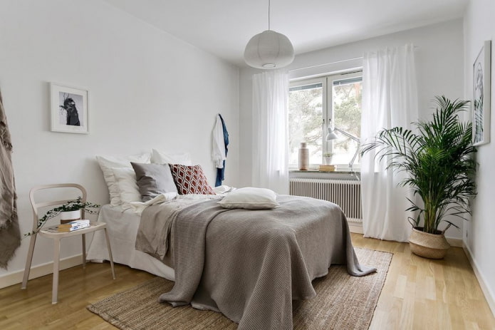 bed met grijze sprei in de slaapkamer