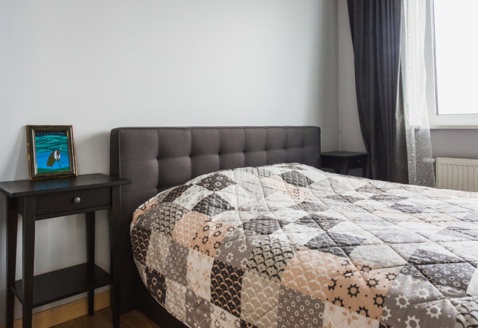 bed met een gewatteerde sprei in de slaapkamer