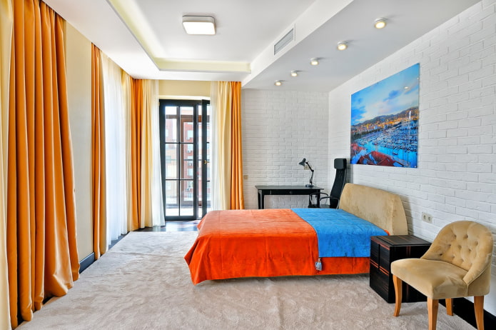 bed met oranje sprei in de slaapkamer