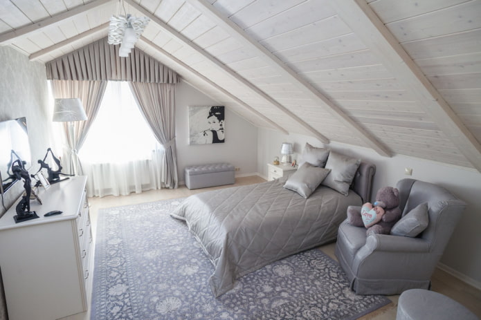 bed met grijze sprei in de slaapkamer