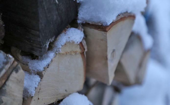 brandhout onder de sneeuw