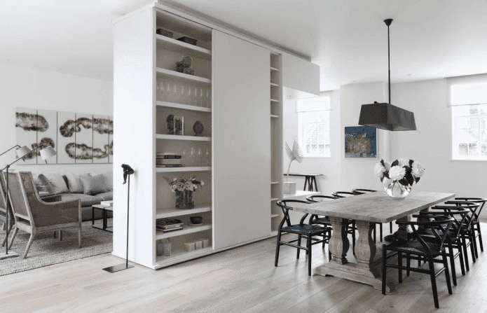 een kast in de vorm van een scheidingswand in het interieur van een keuken-woonkamer