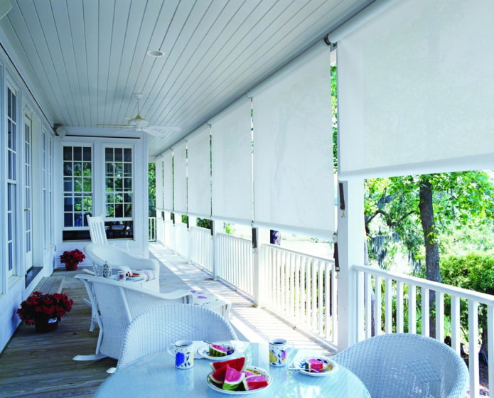 veranda met witte rolgordijnen