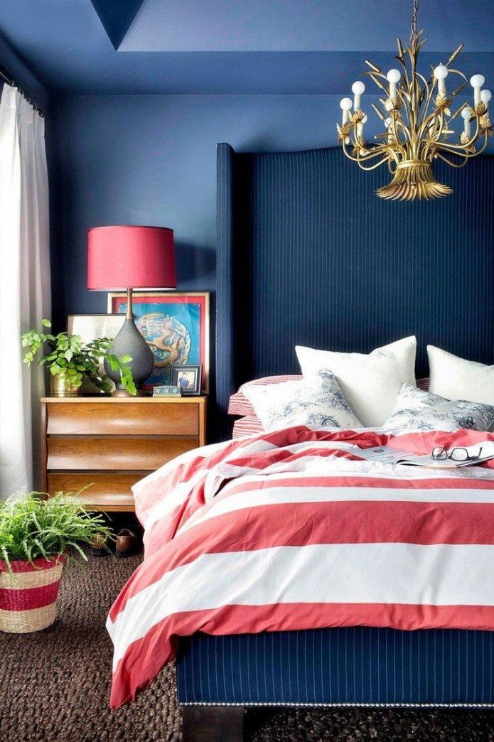 een blauwe slaapkamer met rode accenten