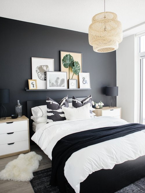 plank met schilderijen boven het bed