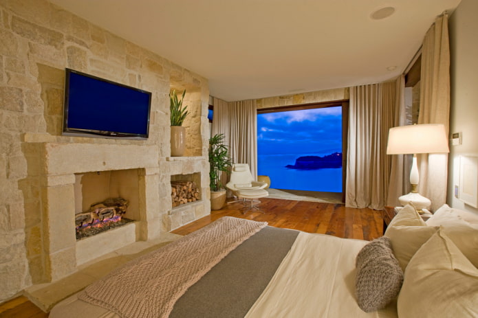 TV in het interieur van de slaapkamer met een open haard