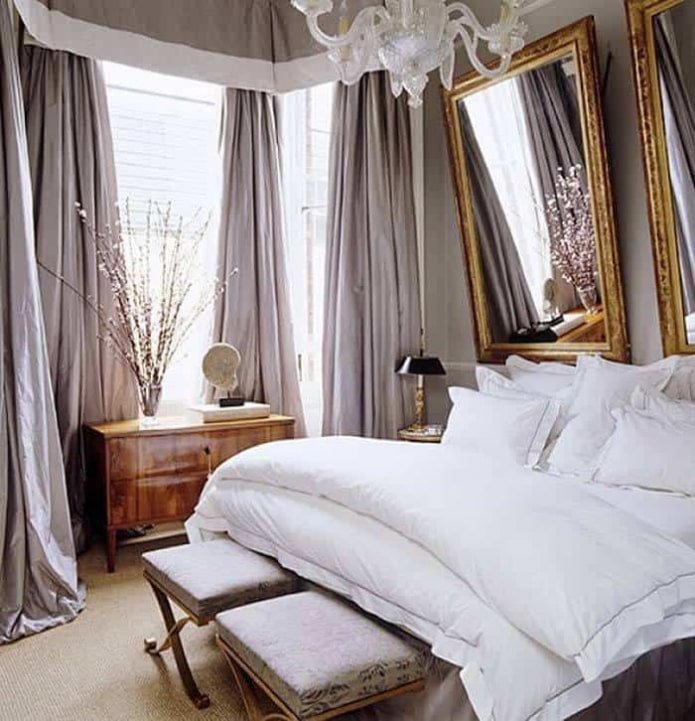 Spiegels in een gesneden lijst boven het bed